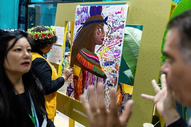 November 16, 2022, Sharm El Sheikh, South Sinai, Egypt: Participants talk as a woman paints a portrait of indigenous person during the COP27 UN Climate Change Conference, held by UNFCCC in Sharm El-Sheikh International Convention Center. COP27, running from November 6 to November 18 in Sharm El Sheikh focuses on implementation of measures already agreed during previous COPs. The Conference in Sharm El Sheikh focuses also on the most vulnerable communities as the climate crisis hardens life conditions of those already most disadvantaged. Sharm El Sheikh Egypt - ZUMAs197 20221116_zaa_s197_262 Copyright: xDominikaxZarzyckax