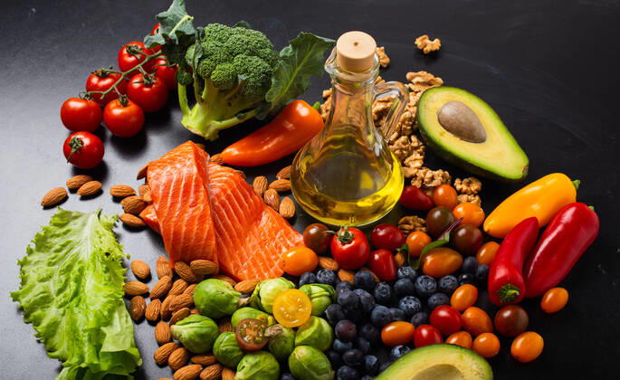 Healthy diet and nutrition food rich in vitamins and omega-3 concept Healthy diet and nutrition food rich in vitamins and omega-3 concept, assorted fresh vegetables, green salad, fruit, fish salmon, nuts, blueberries, bottle of olive oil on black chalk board background. Copyright: xZoonar.com OlenaxYeromenkox 18147162