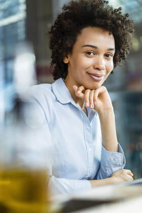 Smiling businesswoman with hand on chin at office model released, Symbolfoto, DIGF19060