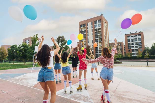 Friends holding colorful balloons roller skating at sports court model released, Symbolfoto, MEUF08475