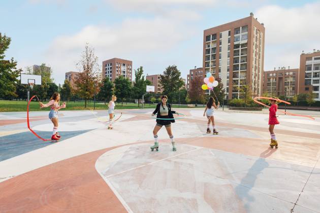 Friends practicing roller skating with hula hoop and ribbons at sports court model released, Symbolfoto, MEUF08574