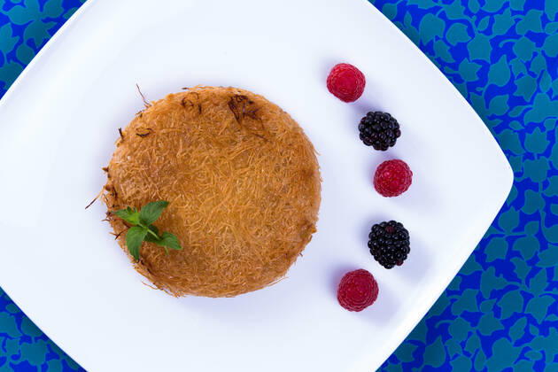 IMAGO Creative, Food, Künefe RECORD DATE NOT STATED Turkish dessert kunefe on a blue table cloth with mint leaves and berries , 9359294.jpg, Dough, Food, Freshness, Ingredient, Macro, Plate, appetizer, arabic, bakery, baking, berries, blackberries, butter, cheese, cloth, cooking, cuisine, delicious, dessert, dinner, east, ethnic, fillo, fork, golden, gourmet, greek, hot, kadaifi, kadayif, kunafeh, kunefe, leaves, lebanese, lunch, meal, mediterranean, middle eastern, mint, pastry, raspberry, restaurant, shredded, strawberry, sweet, syrup, table, traditional, turkish,