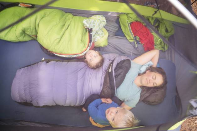 A mom and two young childen lie in their sleeping bags in a tent Maupin, Oregon, United States CR_AXTH22120116-1077437-01 ,model released, Symbolfoto