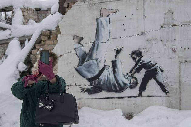 Bilder des Jahres 2022, News 12 Dezember Graffiti Made By Banksy In The Borodianka And Hostomel Towns Near Kyiv A woman is taking a selfie with a graffiti made by Banksy on the wall of a destroyed residential building among debris covered by snow in Borodianka, Ukraine, on December 6, 2022 Borodianka Ukraine  Copyright: xMaxymxMarusenkox originalFilename: musienko-notitle221206_np5ce.jpg