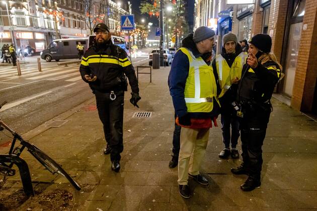 ROTTERDAM - Volunteers and police with Moroccan football supporters after the semi-final match between Morocco and France at the World Cup in Qatar. ANP JEFFREY GROENEWEG netherlands out - belgium out