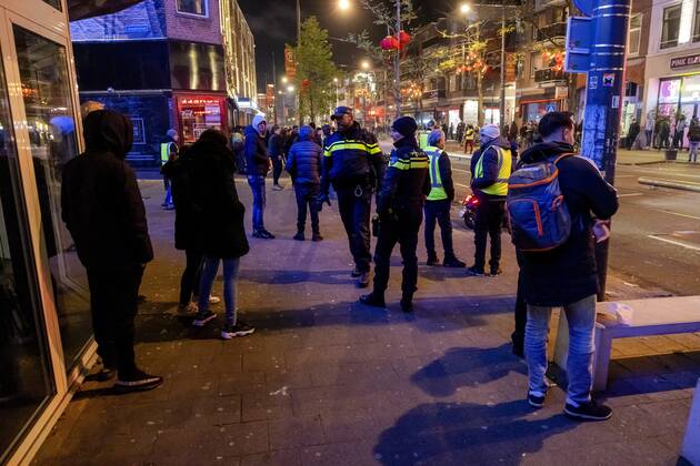 ROTTERDAM - Volunteers and police with Moroccan football supporters after the semi-final match between Morocco and France at the World Cup in Qatar. ANP JEFFREY GROENEWEG netherlands out - belgium out
