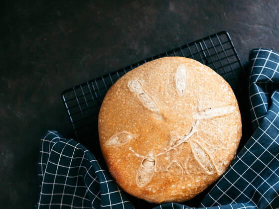 Wheat round sourdough bread, copy space, top view Wheat round sourdough bread. Top view of delicious homemade sourdough bread on black background with copy space. Home made sourdough bread making concept. Copyright: xZoonar.com OlgaxSergeevax 15499571