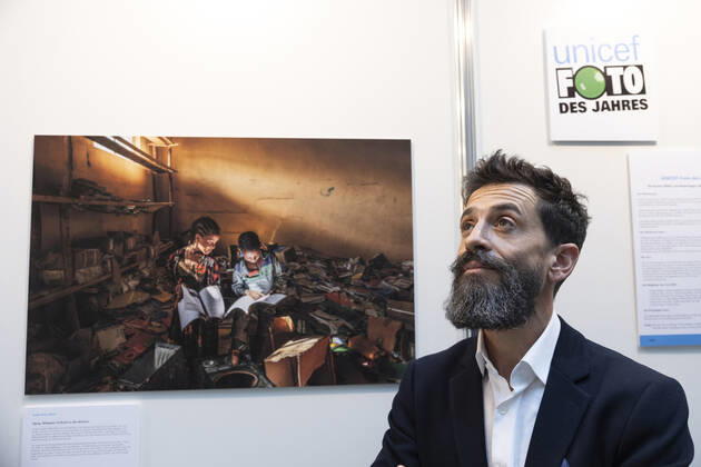 Der Fotograf Eduardo Soteras am 22.12.2022 vor dem Unicef-Foto des Jahres 2022 in der Ausstellung im Haus der Bundespressekonferenz in Berlin. Das Unicef-Foto des Jahres 2022 des renommierten argentinischen Fotografen Eduardo Soteras zeigt zwei Kinder, die sich in der zerstoerten Bibliothek einer Grundschule in der aethiopischen Region Tigray in Buecher vertiefen. (Siehe epd-Meldung vom 22.12.2022) EDITORIAL USE ONLY