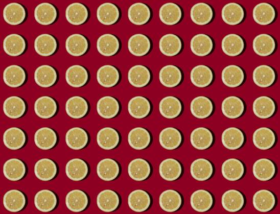 Pattern of halved lemons flat laid against red background, GIOF15643