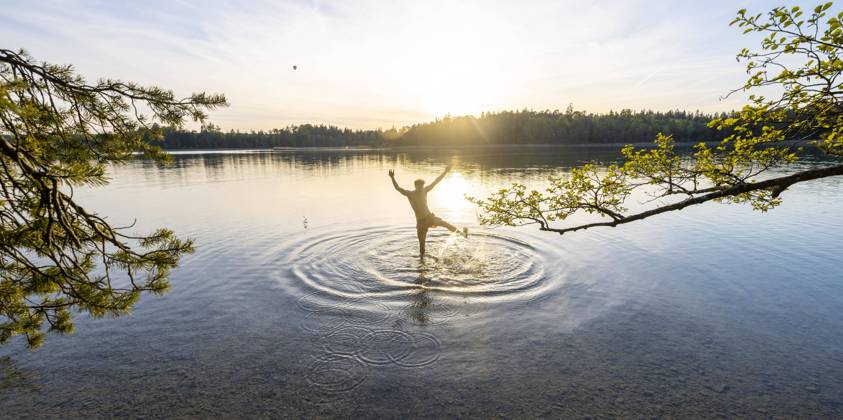 Junger Mann streckt Arme in die Luft, beim Baden im See, spritzendes Wasser, Fohnsee, Osterseen, bei Iffeldorf, Bayern, Deutschland, Europa