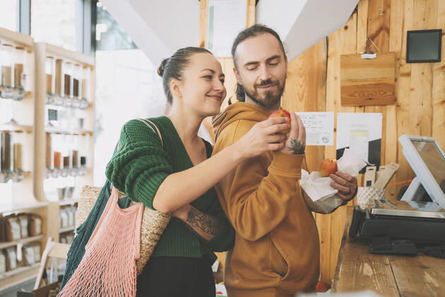 Couple looking at apple near checkout counter in shop model released, Symbolfoto property released, NDEF00208