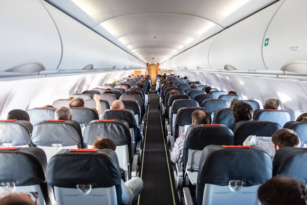 Interior of commercial airplane with passengers on their seats during flight. Interior of commercial airplane with unrecognizable passengers on their seats during flight shot from the rear of airplane. Copyright: xZoonar.com MatejxKastelicx 12419720