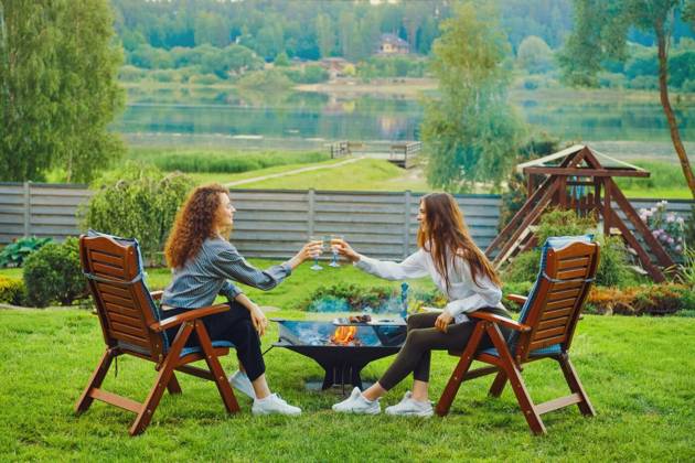  Two friends clinking glasses in backyard, Two women clinking wine glasses in backyard, Two women clinking wine glasses in backyard model released, Symbolfoto , 28.11.2022, Copyright: xBoomeartx Panthermedia33086485.jpg