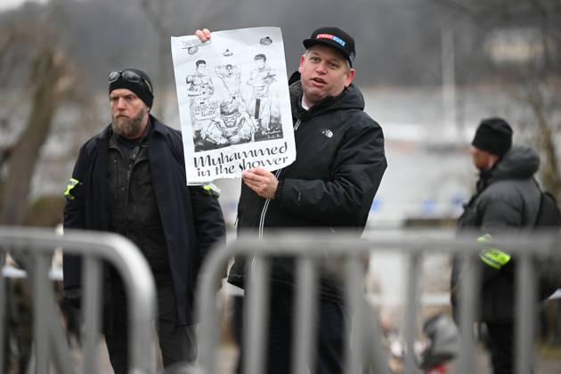STOCKHOLM 20230121 Far-right politician Rasmus Paludan holds up a poster, drawing, as he holds a public rally near the Turkish embassy on Saturday STOCKHOLM SWEDEN x10080x,  Copyright: xFredrikxSandberg TTx PALUDAN TURKIETS AMBASSAD TTABB0000000000153760
