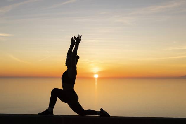 Woman with arms raised practicing yoga in front of sea model released, Symbolfoto, LJF02458