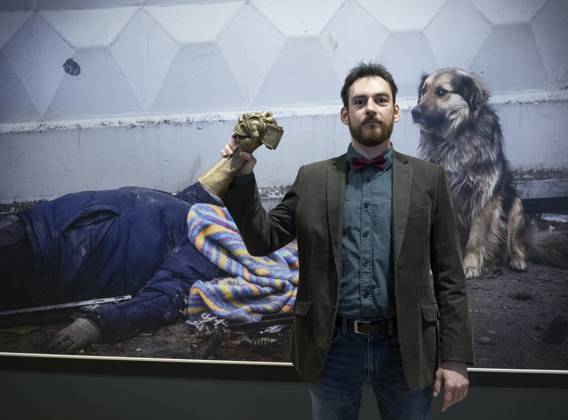 Czech photographer Vojtech Darvik Maca poses with the Czech Press Photo 2022 main prize in front of his winning photo from the massacre in Bucha, Ukraine, on January 31, 2023, in Prague, Czech Republic. (CTKxPhoto MichaelaxRihova) CTKPhotoP2023013108254  P2023013108254