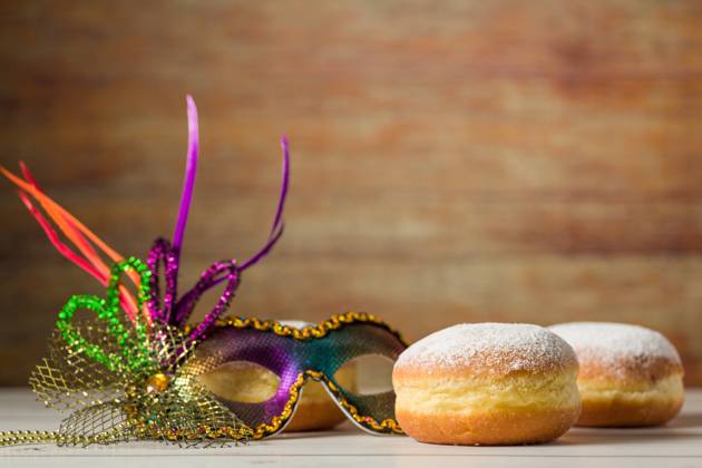 Symbolbild Fasching und Rosenmontag. Berliner, Krapfen oder Pfannkuchen mit einer Faschingsmaske