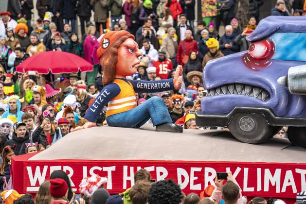 IMAGO Creative, Gesellschaft, Fasching Rosenmontagszug in Düsseldorf, Strassenkarneval, Motivwagen im Karneval, von Wagenbauer Jacques Tilly, Klimaaktivisten der Letzten Generation blockieren einen qualmenden LKW mit Braunkohle aus Garzweiler, Rosenmontagszug Tilly Wagen