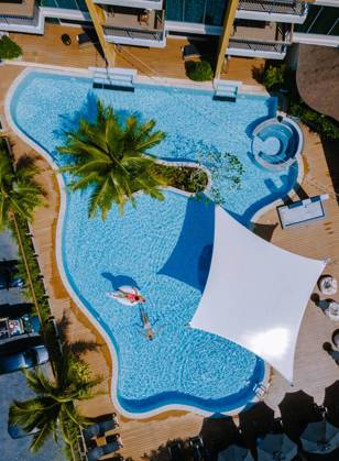 View from above at a swimming pool, couple men and women in swimming pool, drone view Drone view at the pool with palm trees, a couple of men and women in a swimming pool view from above Copyright: xZoonar.com FokkexBaarssenx 19376707 ,model released, Symbolfoto ,property released