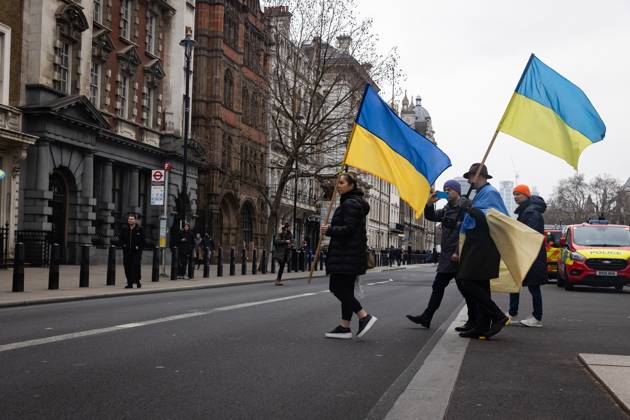 February 24, 2023, London, United Kingdom: People holding Ukrainian flags cross the road in Whitehall opposite Downing Street in London. The world is marking the one-year anniversary of the full-scale Russian invasion of Ukraine today. London United Kingdom - ZUMAs197 20230224_zaa_s197_494 Copyright: xTejasxSandhux