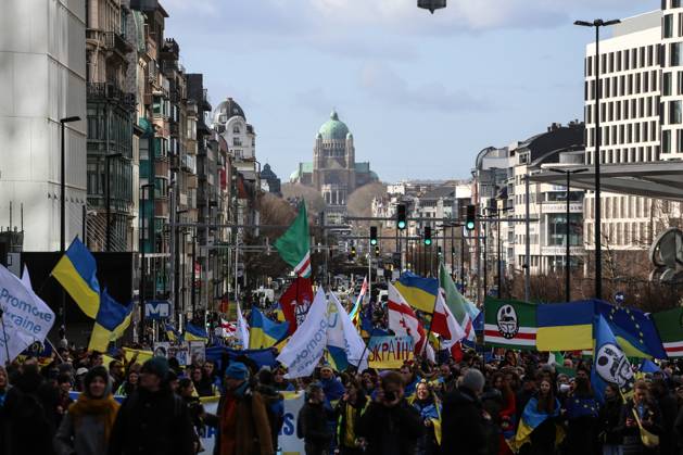 February 25, 2023, Brussels, Brussels Capital Region, Belgium: People hold signs, Ukrainian and Belarusian flags, and flags of the Chechen Republic of Ichkeria during a demonstration in occasion of the one-year anniversary of Russia s invasion of Ukraine in Brussels, Belgium, February 25, 2023. Brussels Belgium - ZUMAm177 20230225_zip_m177_006 Copyright: xValeriaxMongellix