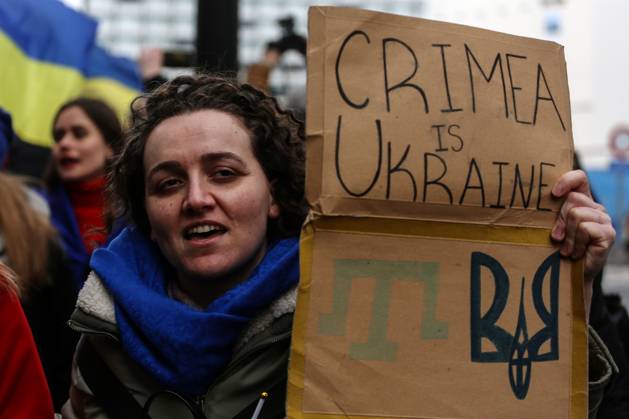 February 25, 2023, Brussels, Brussels Capital Region, Belgium: A demonstrator holds a sign reading Crimea is Ukraine during a protest in occasion of the one-year anniversary of Russia s invasion of Ukraine in Brussels, Belgium, February 25, 2023. Brussels Belgium - ZUMAm177 20230225_zip_m177_008 Copyright: xValeriaxMongellix