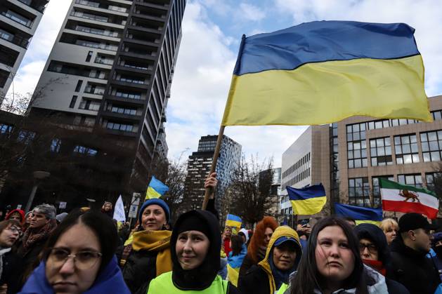 February 25, 2023, Brussels, Brussels Capital Region, Belgium: Demonstrators hold signs and Ukrainian flags during a demonstration in occasion of the one-year anniversary of Russia s invasion of Ukraine in Brussels, Belgium, February 25, 2023. Brussels Belgium - ZUMAm177 20230225_zip_m177_025 Copyright: xValeriaxMongellix