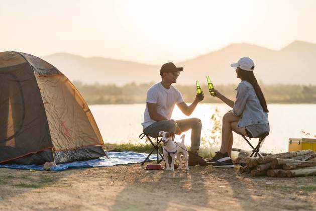Young adult Asian couple drinking beer beside their tent with dog Young adult Asian couple drinking beer beside their tent campsite while sunset. Camping trip with dog outdoor activity campsite concept. Copyright: xZoonar.com VichayaxKiatying-Angsuleex 16422249 ,model released, Symbolfoto ,property released