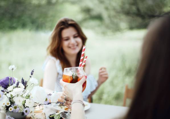Cheerful woman with cocktail during banquet Happy young female with alcohol cocktail smiling and proposing toast while sitting at table during banquet in garden Copyright: xZoonar.com DashaxPetrenkox 16943769 ,model released, Symbolfoto ,property released