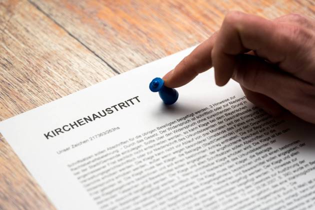 Kirchenaustritt, Brief mit Überschrift: Kirchenaustritt. Symbolbild, eine Hand wirft eine Figur um