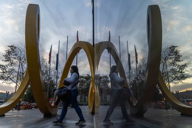 April 3, 2023, Santiago, Metropolitana, Chile: A woman is reflected in a window on a street in Santiago, Chile, at sunset. Santiago Chile - ZUMAb332 20230403_zip_b332_001 Copyright: xMatiasxBasualdox