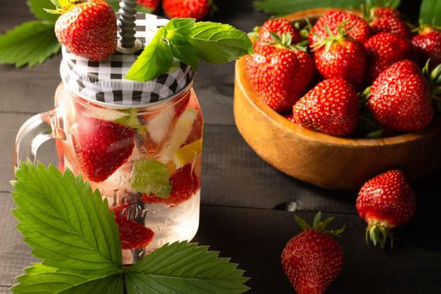 Summer cold drink with mint, ice, lemon and strawberries and wooden bowl of fresh strawberries on black wooden surface., Summer cold drink with mint, ice, lemon and strawberries and a wooden bowl of fresh strawberries on a black wooden surface., Summer cold drink with mint, ice, lemon and strawberries and a wooden bowl of fresh strawberries on a black wooden surface., 26.03.2023, Copyright: xJeanniex Panthermedia33979403.jpg