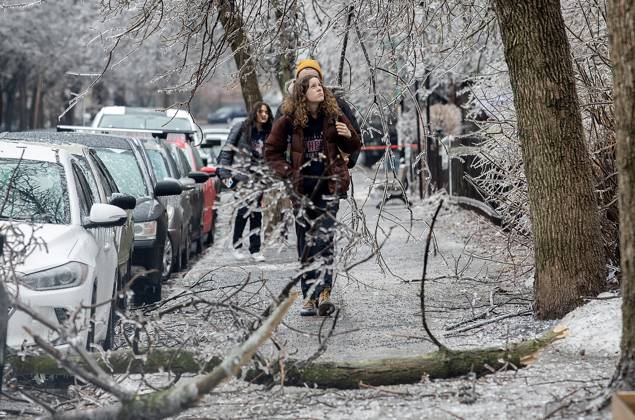 April 5, 2023, Montreal, PQ, Canada: People look up as fallen tree branches block a street following an accumulation of freezing rain in Montreal, Wednesday, April 5, 2023. Montreal Canada - ZUMAc35_ 20230405_zaf_c35_135 Copyright: xGrahamxHughesx