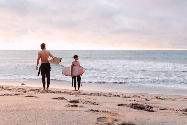 Distant male friends with surfboards and naked torso walking along wet sandy coast near waving sea and looking away during sunset, Model released NicoMortarini_ID13416_408702_012 Copyright: xNicoxMortarinix MR