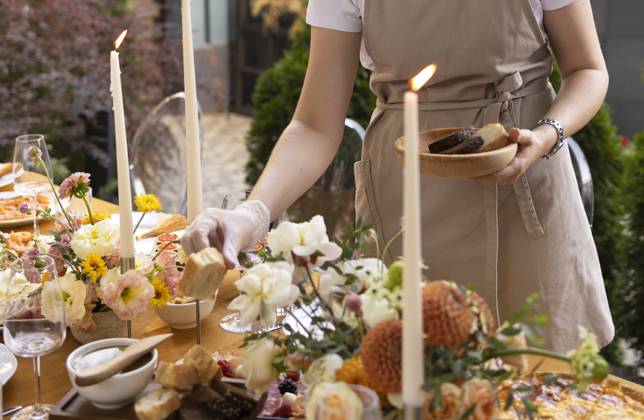 Wedding table for guests, decorated with candles, are served with cutlery and crockery and covered with yellow tablecloth Wedding. Banquet. Chairs and a table for guests, decorated with candles, are served with cutlery and crockery and covered with yellow tablecloth. Waiter setting table stands on a green lawn in the backyard banquet area ,model released, Symbolfoto Copyright: xZoonar.com DashaxPetrenkox 19754723 ,model released, Symbolfoto ,property released