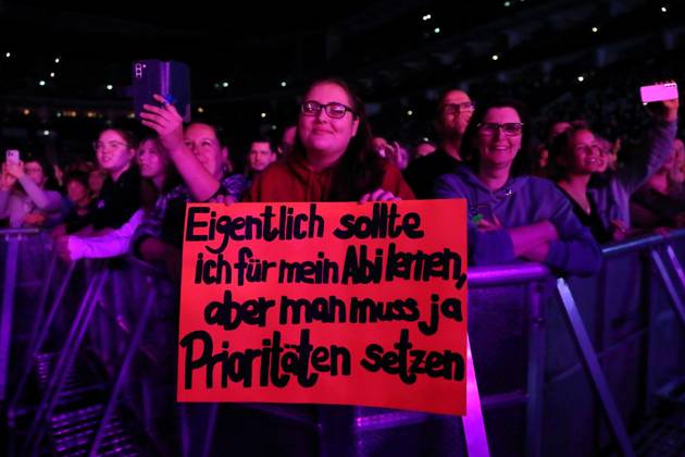 Eine Frau hält ein Plakat mit der Aufschrift Eigentlich sollte ich für mein Abi lernen, aber man muss ja Prioritäten setzen bei einem Konzert von Johannes Oerding in der Mercedes-Benz Arena in Berlin, 15. April 2023. Johannes Oerding Konzert Berlin