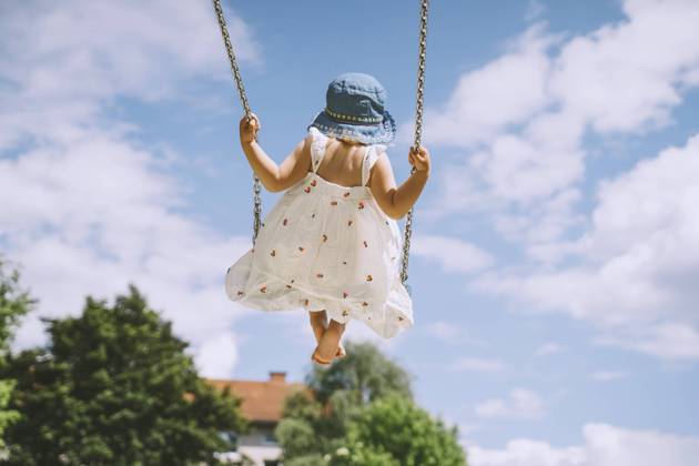 Girl swinging on swing in front of cloudy sky model released, Symbolfoto, NDEF00458