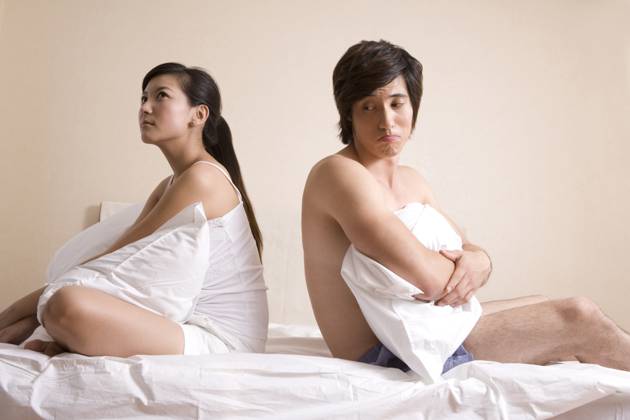 Chinese couple sitting on bed Beijing China Copyright: xLanexOateyx bji01530212