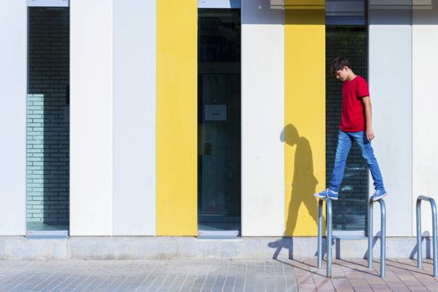 IMAGO Creative, Urban Lifestyle Portrait of a young teen sitting on urban cycle stands against a wall Granollers, Catalonia, Spain CR_RAFE230222-1128855-01 ,model released, Symbolfoto