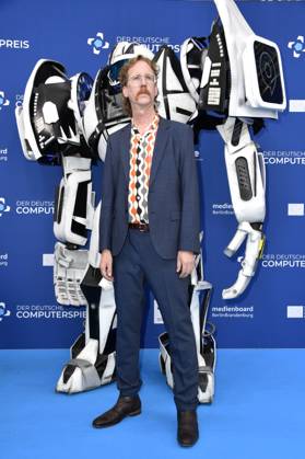 Uke Bosse mit Gamescom Bot bei der Verleihung des Deutschen Computerspielpreises 2023 im Spindler & Klatt. Berlin, 11.05.2023