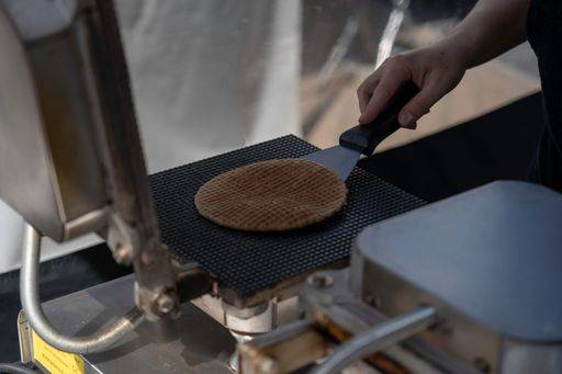A closeup shot of a person at a local market making traditional dutch stroopwafel waffles *** einer closeupe erschossen des einer person im einer Einheimischer Markt machend traditionelle niederlaendisch stroopwafel Waffeln 7321892 RECORD DATE NOT STATED