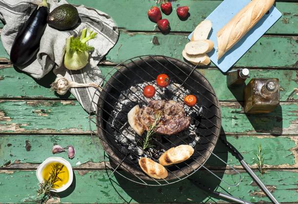 Meat, tomatoes and baguette slices cooking on barbecue grill property released, HHF05876