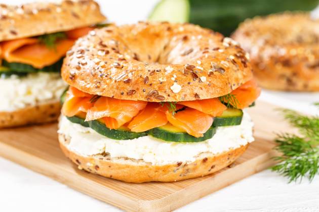 Bagel Brötchen Sandwich zum Frühstück belegt mit Lachs Fisch auf einem Brett in Stuttgart, Deutschland Stuttgart, Deutschland - 15. März 2023: Bagel Brötchen Sandwich zum Frühstück belegt mit Lachs Fisch auf einem Brett in Stuttgart, Deutschland. Copyright: xZoonar.com MarkusxMainkax 20140603