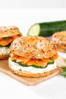 Bagel Brötchen Sandwich zum Frühstück belegt mit Lachs Fisch auf einem Brett Hochformat in Stuttgart, Deutschland Stuttgart, Deutschland - 15. März 2023: Bagel Brötchen Sandwich zum Frühstück belegt mit Lachs Fisch auf einem Brett Hochformat in Stuttgart, Deutschland. Copyright: xZoonar.com MarkusxMainkax 20140696