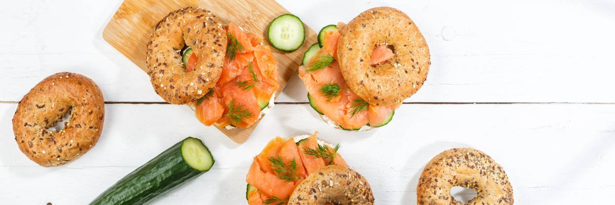 Bagel Brötchen Sandwich zum Frühstück belegt mit Lachs Fisch von oben auf einem Holzbrett Panorama in Stuttgart, Deutschland Stuttgart, Deutschland - 15. März 2023: Bagel Brötchen Sandwich zum Frühstück belegt mit Lachs Fisch von oben auf einem Holzbrett Panorama in Stuttgart, Deutschland. Copyright: xZoonar.com MarkusxMainkax 20140717