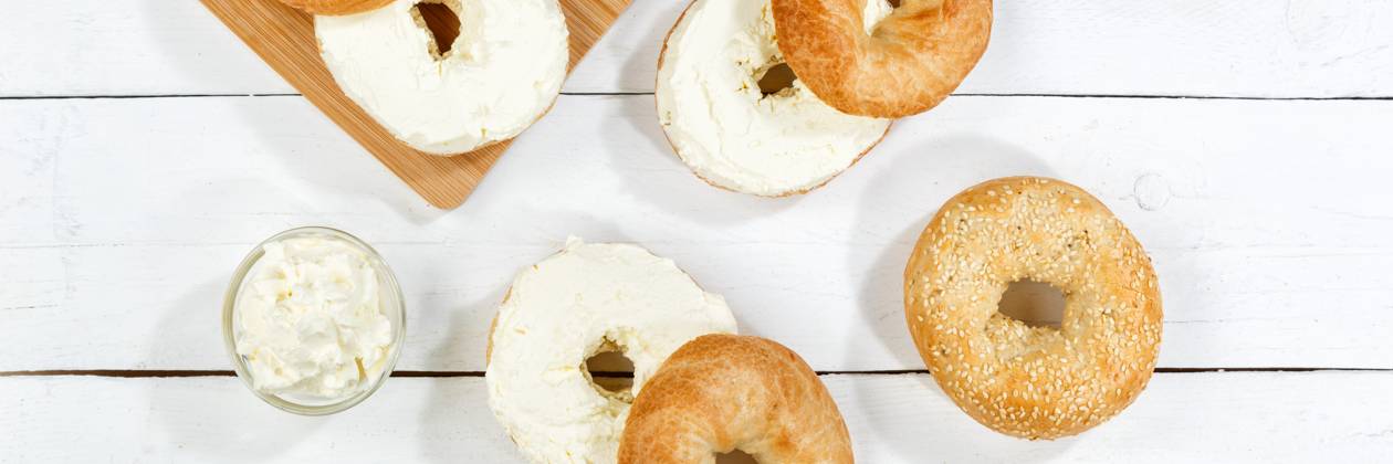Bagel Brötchen Sandwich zum Frühstück belegt mit Frischkäse auf Holzbrett von oben Panorama in Stuttgart, Deutschland Stuttgart, Deutschland - 18. März 2023: Bagel Brötchen Sandwich zum Frühstück belegt mit Frischkäse auf Holzbrett von oben Panorama in Stuttgart, Deutschland. Copyright: xZoonar.com MarkusxMainkax 20141896