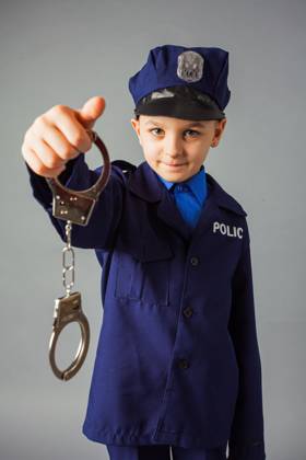 IMAGO Creative, Gesellschaft, Fasching Little boy pretending to be a police officer. Little boy pretending to be a police officer. Cute boy in a policeman costume showing handcuffs over grey background. ,model released, Symbolfoto Copyright: xZoonar.com OksanaxShufrychx 15111101 ,model released, Symbolfoto ,property released