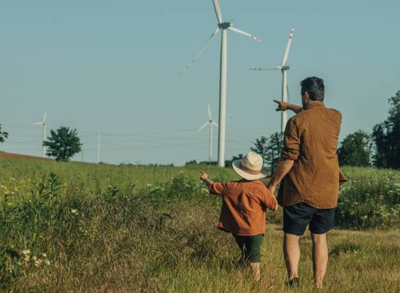 Father and son gesturing towards wind turbines at field model released, Symbolfoto, VSNF01080