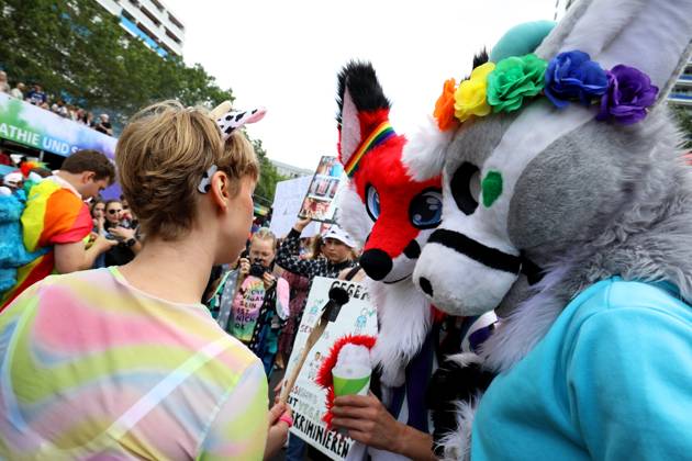 CHRISTOPHER STREET DAY 2023 - BERLIN PRIDE 2023 - CSD Berlin - Am 22. Juli 2023 zieht der CSD in Berlin unter dem bilingualen Motto BE THEIR VOICE AND OURS! ... FÜR MEHR EMPATHIE UND SOLIDARITÄT! zum 45. Mal durch die Hauptstadt. Die bunte CSD-Parade startet als Demonstration an der Leipziger Straße und führt auf einer 7,4 Kilometer langen Strecke über den Potsdamer Platz, vorbei am Nollendorfplatz, über die Siegessäule (Großer Stern) und der Straße des 17. Juni zum Endpunkt am Brandenburger Tor. Die Veranstalter rechnen im Tagesverlauf mit bis zu 500.000 Teilnehmerinnen und Teilnehmern. Demoteilnehmer mit Plüschmasken.