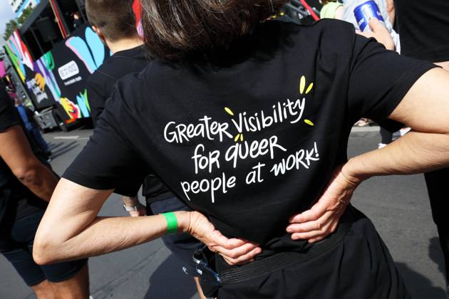 CHRISTOPHER STREET DAY 2023 - BERLIN PRIDE 2023 - CSD Berlin - Am 22. Juli 2023 zieht der CSD in Berlin unter dem bilingualen Motto BE THEIR VOICE AND OURS! ... FÜR MEHR EMPATHIE UND SOLIDARITÄT! zum 45. Mal durch die Hauptstadt. Die bunte CSD-Parade startet als Demonstration an der Leipziger Straße und führt auf einer 7,4 Kilometer langen Strecke über den Potsdamer Platz, vorbei am Nollendorfplatz, über die Siegessäule (Großer Stern) und der Straße des 17. Juni zum Endpunkt am Brandenburger Tor. Die Veranstalter rechnen im Tagesverlauf mit bis zu 500.000 Teilnehmerinnen und Teilnehmern. Demoteilnehmer trägt schwarzes T-Shirt mit Schriftzug: Greater Visibility for queer people at Work! (Mehr Sichtbarkeit für queere Menschen